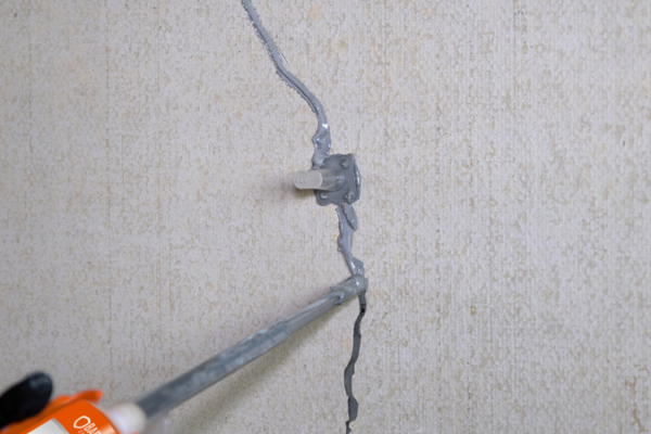 Réparation de fissure murale avec mastic.