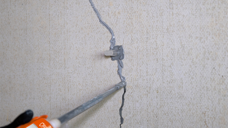 Réparation de fissure murale avec mastic.