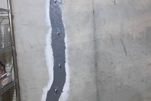 Mur béton avec fissure réparée visible