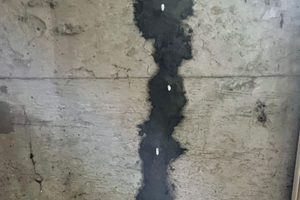 Réparation d'une fissure sur un mur en béton.