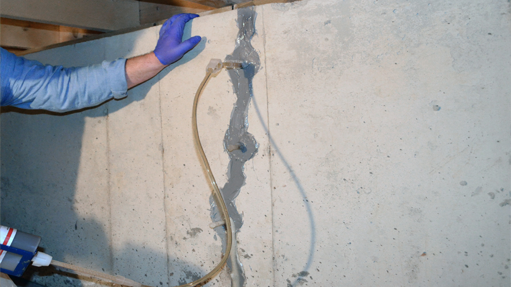 Réparation de fissure dans mur en béton.